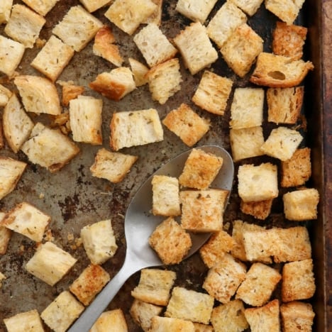 baked croutons on a pan with a spoon