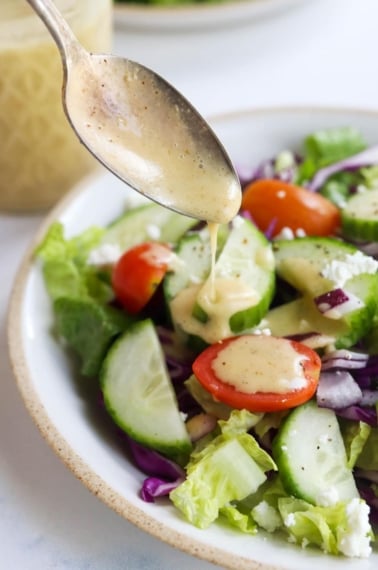 salad dressing on spoon over salad
