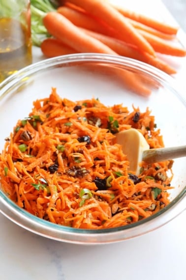 carrot salad in glass bowl with spatula